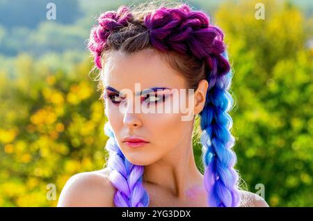 Pigtail. Primo piano sulla faccia di bellezza della ragazza. Ragazza con kanekalon colorato intrecciato nei capelli. Bella donna capelli ombre viola colorato e trucco professionale Foto Stock