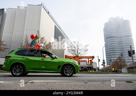 Monaco, Germania. 6 novembre 2024. I dipendenti BMW guidano un SUV BMW lungo una strada davanti allo stabilimento BMW durante uno sciopero di avvertimento. Mercoledì i dipendenti del settore metallurgico ed elettrico in Baviera continuano i loro avvertimenti. Il sindacato IG Metall ha annunciato una sospensione temporanea del lavoro per 74 imprese in Baviera. Crediti: Lennart Preiss/dpa/Alamy Live News Foto Stock