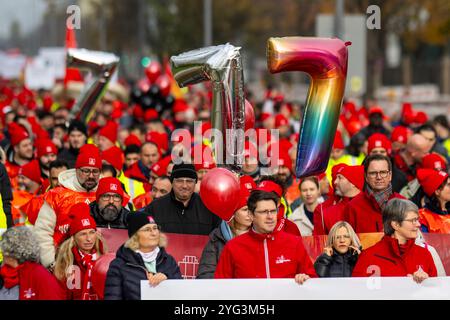 Monaco, Germania. 6 novembre 2024. I dipendenti BMW marciano dall'altra parte della strada di fronte allo stabilimento BMW durante uno sciopero di avvertimento. Mercoledì i dipendenti del settore metallurgico ed elettrico in Baviera continuano i loro avvertimenti. Il sindacato IG Metall ha annunciato una sospensione temporanea del lavoro per 74 imprese in Baviera. Crediti: Lennart Preiss/dpa/Alamy Live News Foto Stock