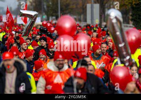 Monaco, Germania. 6 novembre 2024. I dipendenti BMW marciano dall'altra parte della strada di fronte allo stabilimento BMW durante uno sciopero di avvertimento. Mercoledì i dipendenti del settore metallurgico ed elettrico in Baviera continuano i loro avvertimenti. Il sindacato IG Metall ha annunciato una sospensione temporanea del lavoro per 74 imprese in Baviera. Crediti: Lennart Preiss/dpa/Alamy Live News Foto Stock