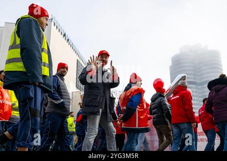Monaco, Germania. 6 novembre 2024. Un dipendente BMW mostra il numero sette durante uno sciopero di avvertimento davanti allo stabilimento BMW. Mercoledì i dipendenti del settore metallurgico ed elettrico in Baviera continuano i loro avvertimenti. Il sindacato IG Metall ha annunciato una sospensione temporanea del lavoro per 74 imprese in Baviera. Crediti: Lennart Preiss/dpa/Alamy Live News Foto Stock