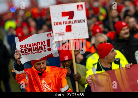 Monaco, Germania. 6 novembre 2024. I dipendenti BMW marciano dall'altra parte della strada di fronte allo stabilimento BMW durante uno sciopero di avvertimento. Mercoledì i dipendenti del settore metallurgico ed elettrico in Baviera continuano i loro avvertimenti. Il sindacato IG Metall ha annunciato una sospensione temporanea del lavoro per 74 imprese in Baviera. Crediti: Lennart Preiss/dpa/Alamy Live News Foto Stock