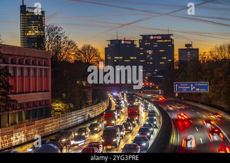 Traffico serale, in parte con ingorghi, traffico lento sull'autostrada A40, skyline di Essen, torre sinistra RWE, sede centrale del gruppo Evonik Foto Stock