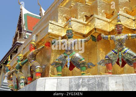 Bangkok, Thailandia - demoni mitici Yaksha che sostengono un chedi dorato o stupa buddista, parte dell'architettura del Grand Palace Foto Stock