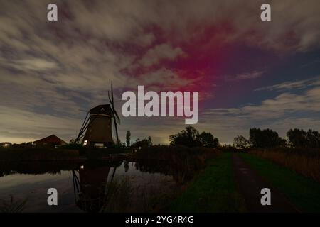 aurora boreale di colore viola o aurora boreale sopra un mulino a vento olandese chiamato Rietveldse Molen vicino al villaggio di Hazerswoude-dorp, Paesi Bassi. Foto Stock