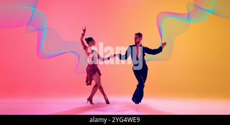 Design creativo. Giovane uomo e donna artistici, ballerini che si esibiscono in danza latina con abiti eleganti su sfondo giallo rosa sfumato con luce al neon Foto Stock