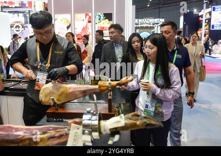 Shanghai. 6 novembre 2024. I visitatori attendono di assaggiare il prosciutto spagnolo durante la settima China International Import Expo (CIIE) nella zona orientale di Shanghai, 6 novembre 2024. I prodotti alimentari e agricoli esposti al CIIE hanno attirato l'attenzione dei visitatori. Crediti: Xu Liang/Xinhua/Alamy Live News Foto Stock