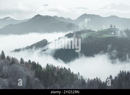 2024 ottobre 27, Slovenia, Rateče - Chiesa di San Tommaso nella nebbia mattutina Foto Stock