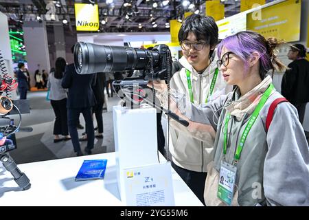 Shanghai. 6 novembre 2024. I visitatori possono sperimentare le attrezzature fotografiche presso lo stand di Nikon presso l'area espositiva dell'industria intelligente e dell'Information Technology durante la settima China International Import Expo (CIIE) nella zona orientale di Shanghai, il 6 novembre 2024. Il CIIE in corso presenta tecnologie all'avanguardia e apparecchiature di fascia alta, fornendo una piattaforma di comunicazione per il nuovo settore dei materiali. Crediti: Zhang Cheng/Xinhua/Alamy Live News Foto Stock