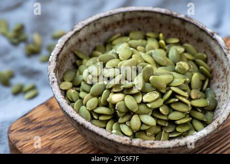 Pepitas, semi di zucca secchi crudi in una vista ravvicinata della ciotola Foto Stock