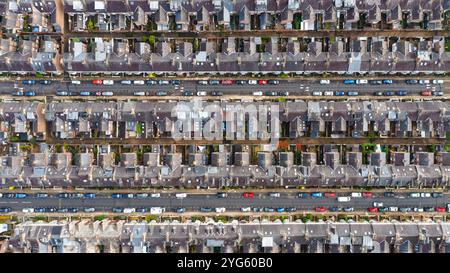 Vista panoramica di Aerila direttamente sopra una grande tenuta residenziale in una città del nord del Regno Unito con strade parallele piene di auto parcheggiate e file di dow Run Foto Stock