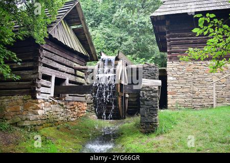 Un mulino in legno rotante con acqua tradizionalmente nel villaggio Foto Stock