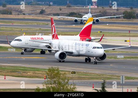 Aeroporto Barajas di Madrid. THY Turkish Airlines A210 neo aereo di linea in manovra con un aereo Iberia alle spalle. Foto Stock