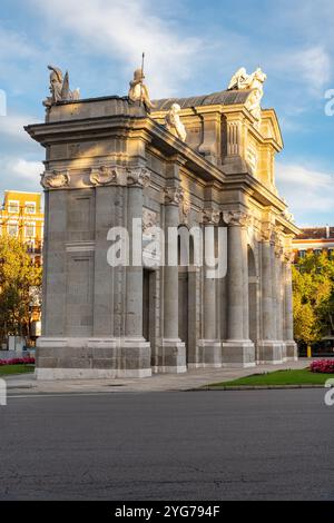Porta di Alcala vista all'alba con i raggi del sole che passano attraverso gli alberi, Madrid, Spagna Foto Stock