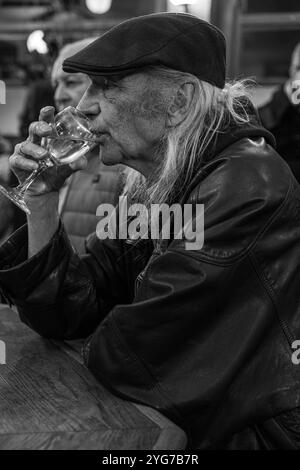 Un uomo anziano beve vino alla French House di Soho, Londra, Regno Unito Foto Stock