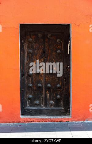 Primo piano di una porta in legno splendidamente intagliata a Cuernavaca, Morelos, che mostra l'artigianato tradizionale messicano e dettagli di design intricati Foto Stock