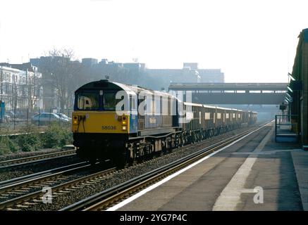 Una locomotiva diesel di classe 58 numero 58036 si dirige a nord attraverso una nebbiosa Kensington Olympia con pietre vuote in lavorazione il 10 marzo 1997. Foto Stock