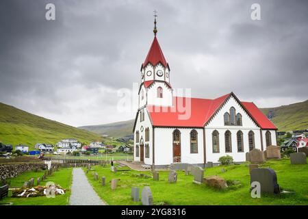 Caratteristica chiesa con tetto rosso nella città di Sandavágur nelle Isole Faroe Foto Stock