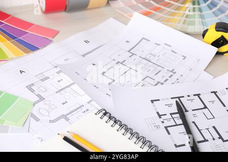 Planimetrie, tabelle di selezione dei colori e metro a nastro su tavolo in legno bianco, primo piano. Decorazione e design Foto Stock