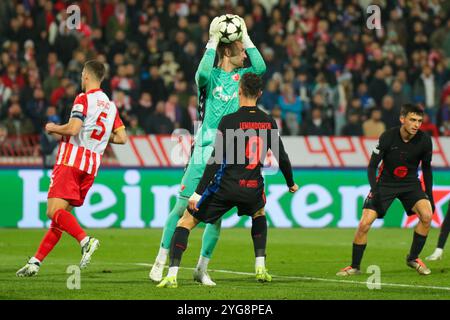 Belgrado, Serbia. 6 novembre 2024. Il portiere Marko Ilic di Crvena Zvezda controlla la palla di fronte a Robert Lewandowski di Barcellona durante la fase MD4 della UEFA Champions League 2024/25 tra FK Crvena Zvezda e FC Barcelona al Rajko Mitic Stadium il 6 novembre 2024. Crediti: Dimitrije Vasiljevic/Alamy Live News Foto Stock