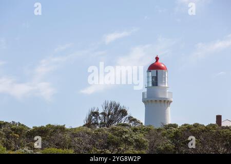 Faro di Cape Schanck, Victoria, Australia, con la costa della penisola di Mornington in vista in una giornata di sole con nuvole sparse Foto Stock