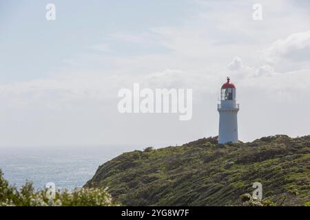 Faro di Cape Schanck, Victoria, Australia, con la costa della penisola di Mornington in vista in una giornata di sole con nuvole sparse Foto Stock