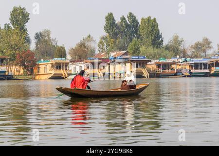 Rainawari, Srinagar, Jammu e Kashmir, India. Donne che pagaiano su una barca tradizionale al lago dal. Foto Stock