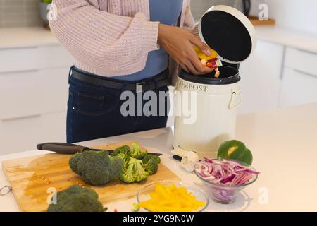 Compostaggio di scarti vegetali in cucina, donna che promuove uno stile di vita ecologico, a casa Foto Stock