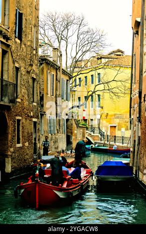 Traffico in barca sul canale d'acqua nella zona residenziale di Venezia, Italia Foto Stock
