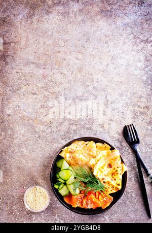 Pancake o crepe sottili con salmone affumicato, cetriolo e aneto su sfondo grigio. Messa a fuoco selettiva Foto Stock