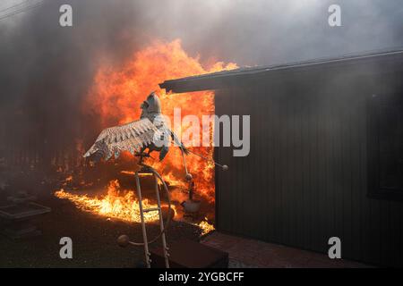 Camarillo, Stati Uniti. 6 novembre 2024. Un ornamento da prato di un gufo di fronte a una casa in fiamme. Il fuoco di montagna si accende attraverso Camarillo con l'aiuto dei venti di Santa Ana. L'incendio ha bruciato più di 10.500 acri con contenimento dello 0%. Credito: SOPA Images Limited/Alamy Live News Foto Stock