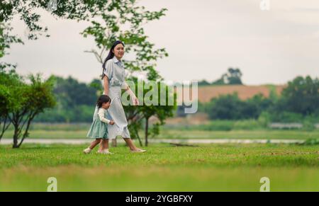 mamma che cammina con la bambina che piange sul campo di erba del parco Foto Stock