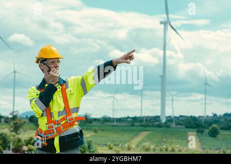 Team di tecnici dell'ingegnere caucasico lavoratori maschi in servizio presso Wind Turbines presso il campo seminterrato della fattoria dei generatori di energia eolica. Foto Stock