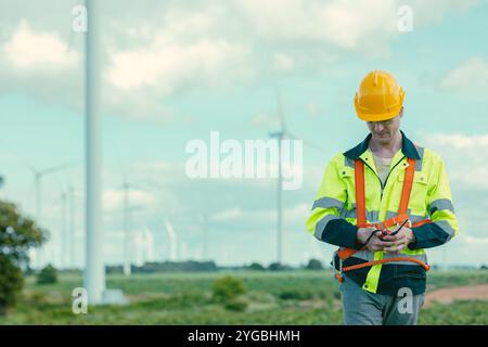 Tecnico ingegnere caucasico lavoratore maschile servizio di manutenzione turbina eolica presso Wind Turbines campo agricolo generatore di energia elettrica all'aperto. Foto Stock