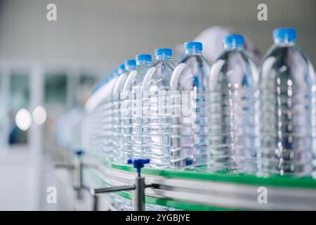 Linea di produzione di acqua potabile sul nastro trasportatore. Bottiglie d'acqua di plastica in una fabbrica di bevande. Industria di bottiglie in PET. Foto Stock