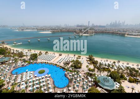 Vista dall'alto della piscina Atlantis The Palm Royal con ombrelloni e lettini intorno alla piscina, Dubai, Emirati Arabi Uniti Foto Stock