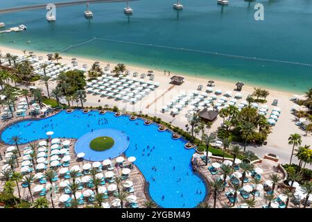 Vista dall'alto della piscina Atlantis The Palm Royal con ombrelloni e lettini intorno alla piscina, Dubai, Emirati Arabi Uniti Foto Stock