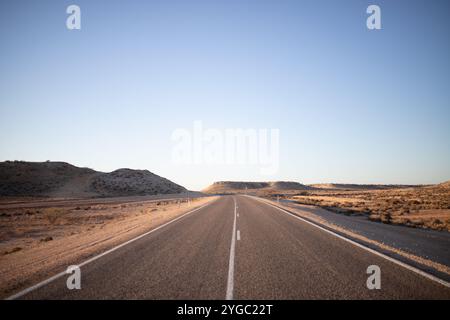 Linee stradali dipinte di bianco su una strada asfaltata. Vista dalla parte centrale della strada sulla Northwest Coastal Highway. Strada utilizzata come strada per camion e. Foto Stock