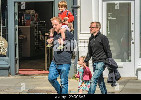 Due papà camminano con i loro figli, trascorrendo del tempo insieme all'aperto. Foto Stock