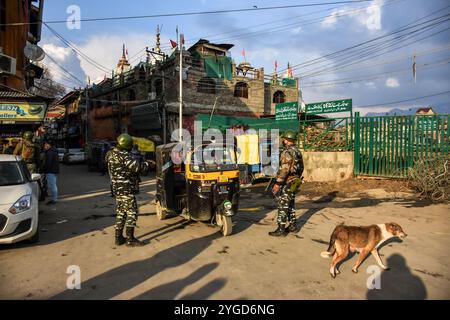 Le truppe paramilitari indiane fermano il traffico civile nei pressi del sito di attacco delle granate a Srinagar, l'amministrazione indiana del Kashmir il 25 gennaio 2022. Due civili sono rimasti feriti dopo che sospetti militanti hanno lobbato la granata alle forze indiane schierate a Hari Singh High Street prima della giornata della Repubblica indiana. Foto Stock