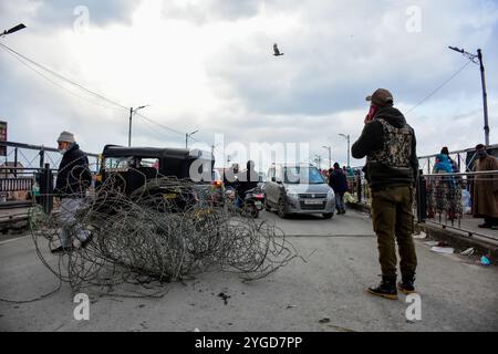 Le forze di polizia indiane fermano il traffico civile nei pressi del sito di attacco delle granate a Srinagar, l'amministrazione indiana del Kashmir il 25 gennaio 2022. Due civili sono rimasti feriti dopo che sospetti militanti hanno lobbato la granata alle forze indiane schierate a Hari Singh High Street prima della giornata della Repubblica indiana. Foto Stock