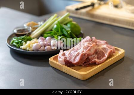 Primo piano per una confezione di ingredienti crudi di maiale ed erbe aromatiche, preparazione per cucinare nel menu di piatti thailandesi. Foto Stock