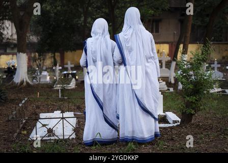 Le suore pregano sulla tomba durante l'osservazione di tutte le anime, a Guwahati, in India, il 2 novembre 2024. All Souls' Day è una festa cristiana Foto Stock