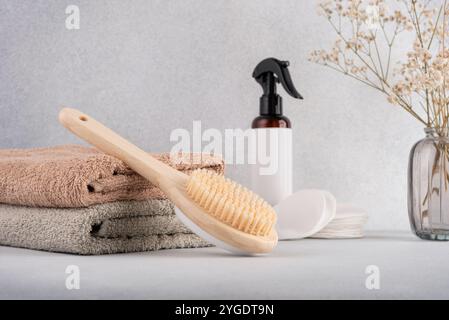 Articoli da toeletta minimalisti per la cura di sé, con spazzola per il corpo in bambù, morbidi asciugamani e prodotti per la cura della pelle biologici. Ideale per spa eco-compatibili o Foto Stock