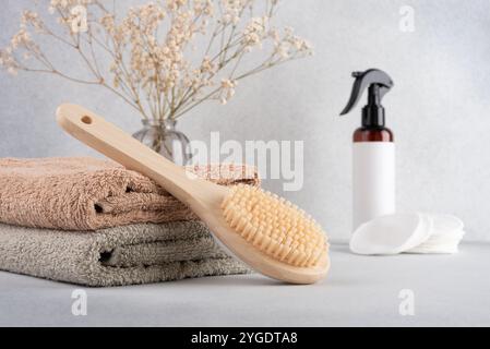Articoli da toeletta minimalisti per la cura di sé, con spazzola per il corpo in bambù, morbidi asciugamani e prodotti per la cura della pelle biologici. Ideale per spa eco-compatibili o Foto Stock