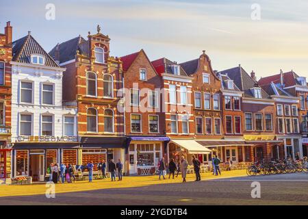 Delft, Paesi Bassi, 8 aprile 2016: Colorata vista sulla strada con negozio di formaggi, case e persone Foto Stock