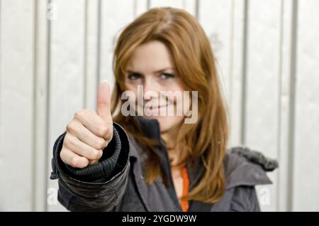 Giovane donna bella mostra pollice in alto Foto Stock