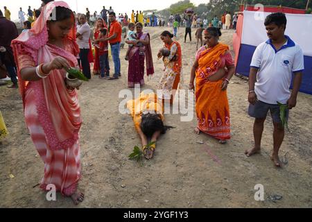 Kolkata, India - 7 novembre 2024: I devoti indù si riunirono lungo il fiume Hooyal a Kolkata al crepuscolo per osservare il tradizionale rituale vedico di Chhath Puja, dedicato al Dio Sole. I devoti offrirono dolci, frutta e fiori al sole che tramonta, un atto simbolico nell'induismo che rappresenta la riverenza per il Sole come guardiano dell'anima, genitore e spirito ancestrale. Chhath Puja, osservata per più giorni, viene celebrata con digiuno, preghiera e offerte, simboleggiando la gratitudine e il rispetto per la natura e le forze della vita. Le rive del fiume erano adornate di fedeli immersi nella devozione, segnando un sereno di Foto Stock