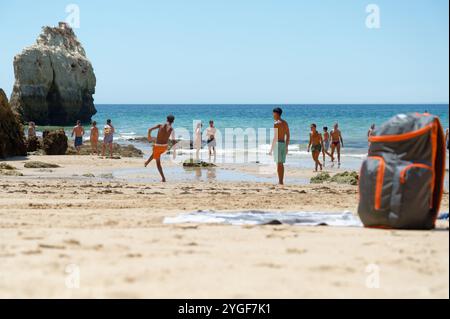 Gli amanti della spiaggia giocano una partita informale di calcio sulle spiagge sabbiose di praia da rocha, godendosi una vivace giornata in riva al mare Foto Stock
