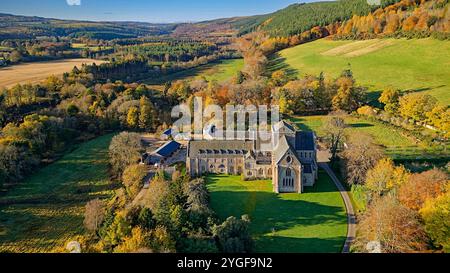 Pluscarden Abbey un monastero cattolico benedettino vicino a Elgin in Scozia circondato da alberi colorati durante il sole autunnale Foto Stock